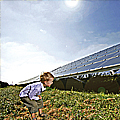 Kleiner Junge blickt auf ein Solarfeld
