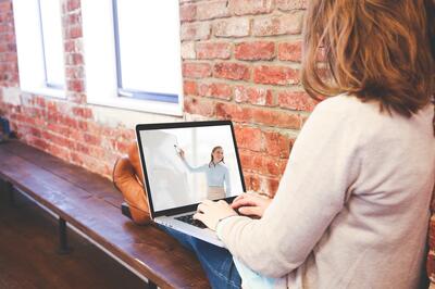 Bild vergrern: Frau mit Laptop auf dem Scho verfolgt Online-Schulung
