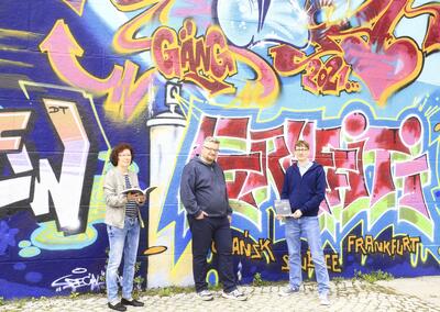 Bild vergrern: Buchbergabe vor dem Graffiti an der Stadtbrcke mit (v. l. n. r.) Archivbibliothekarin Sigrid Riedel, Jan Augustyniak und Archivleiter Dr. Denny Becker.